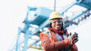 Female engineer smiling confidently while working on a sustainable infrastructure project, representing progress in funding for infrastructure in Nigeria.